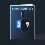 Shiny Blue Dreidel Helgkort<br><div class="desc">En moderniserande,  metallisk,  blå dröm mot en mörk,  nattlig bakgrund. Två av hebreiska brev hittades på en dröm,  nunna och shin,  glöd. Den hebreiska text som lyder "Chag Chanukkah Sameach" (Lycklig Hanukkah) förekommer också i blått och vitt ljus.</div>