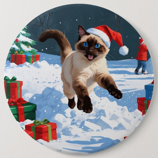 Siamesisk katt springer i snö med julhatt knapp (Framsida)