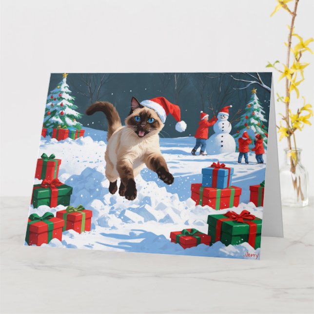 Siamesisk katt springer i snö med julhatt kort (Gul blomma)