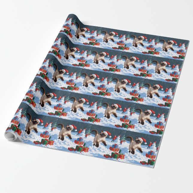 Siamesisk katt springer i snö med julhatt presentpapper (Utrullad)