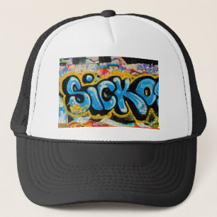 Sickografitti på den texturerade väggen keps
