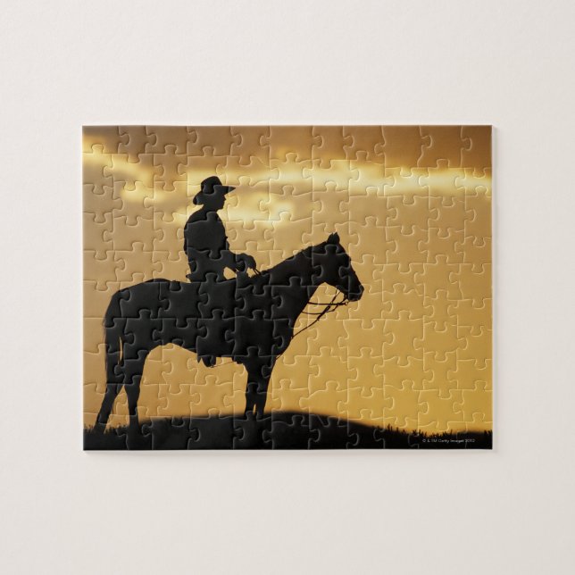 Silhouette cowboy på horseback vid solnedgång elle pussel (Horisontell)