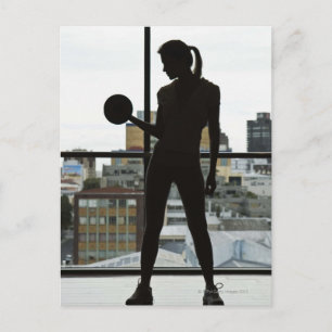 Siluett av kvinna som lyfter vikter på gym vykort