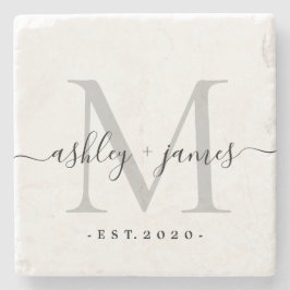 Silverfärgad stenunderlägg med monogram i skrivsti
