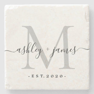 Silverfärgad stenunderlägg med monogram i skrivsti