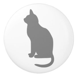 Sittande grå katt vänd åt vänster knopp