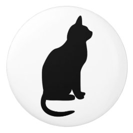 Sittande svart katt vänd åt höger knopp