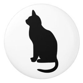 Sittande svart katt vänd åt vänster knopp
