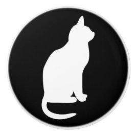 Sittande vit katt vänd åt höger knopp