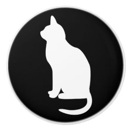 Sittande vit katt vänd åt vänster knopp