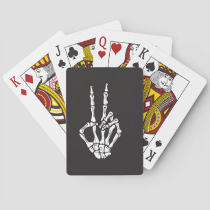 Skeleton Hand skapar ett Fredstecken på en uppsätt Casinokort