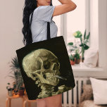 Skeleton med brinnande cigarett | Vincent van Gogh Tygkasse<br><div class="desc">Skullet på en Skeleton med brinnande cigarett (1886) av Vincent van Gogh är en slående och okonventionell likörmålning som innehåller ett mänskligt skalle med en tänd cigarett mellan tänderna. Bakgrunden till mörken förstärker det skelettala figur, medan rökens lilla rök ger en känsla av genombrott och ironi. Denna teckning, som skapades...</div>