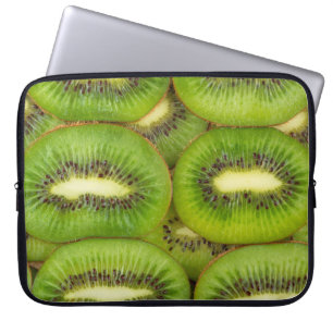 Skivor av färsk och mogen kiwi-frukt i rowsbrun,c laptop fodral