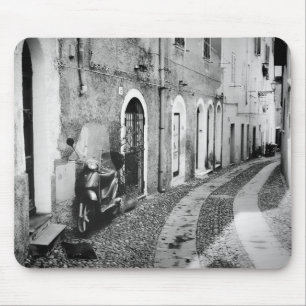 Skotrar på en gata i Italien i svartvitt Musmatta