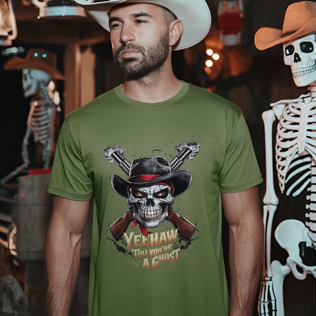 Skull Cowboy - Spooky Vilda western T Shirt (A man wearing a fatigue green t-shirt with a skull cowboy design stands in a dimly lit room)