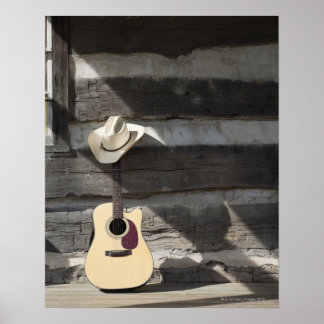 Slanghatt på gitarr som lutar åt loggstugan poster