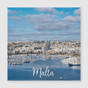 Sliema-hamn med modern byggnad och båtmäster