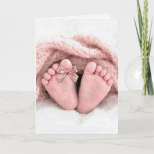 Små flickfötter med en prickig rosett på tån kort