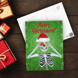 Smiling Skeleton Santa Hat Ornaments Grönt Swirls Vykort<br><div class="desc">Detta vykort har ett leende skelett med ett rött päls Santa Hat med röda depåer och grönt till ögon på gröntens bakgrund med snurrar och gränsar till snöflingor. God jul står i rött.</div>