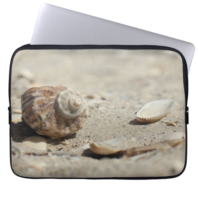 Snäckskal på sanden vid havet laptop sleeve (Framsidan)