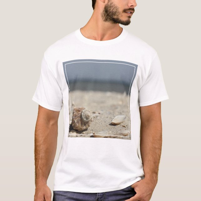 Snäckskal på sanden vid havet tee (Framsida)