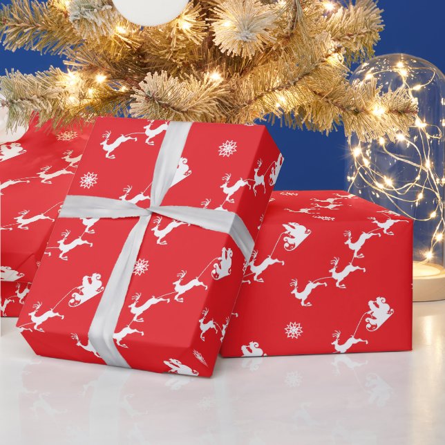Snöflinga och tomte med släde på röd julbakgrund presentpapper (Helgdagar)