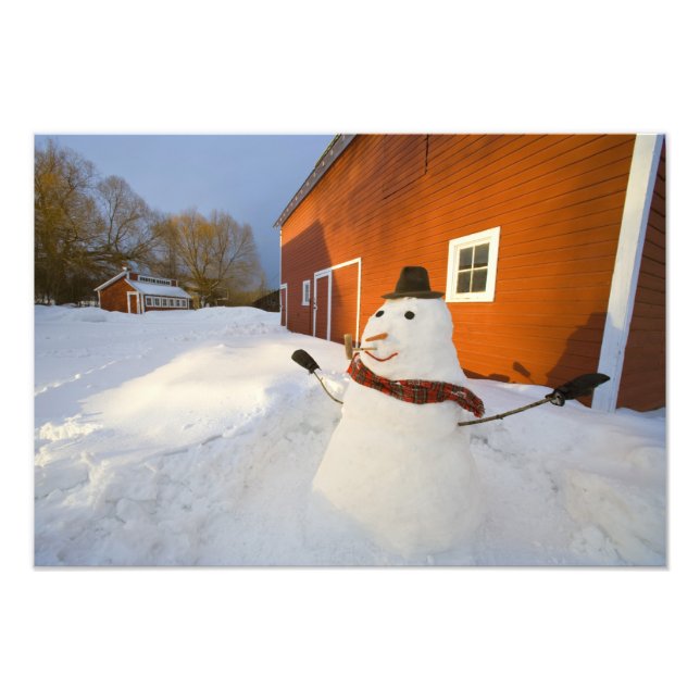 Snögubbe framför den röda ladan i Columbia Falls Fototryck (Framsidan)