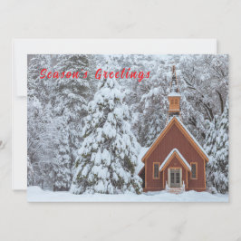 Snöig kyrka i vinterlandskap julkort