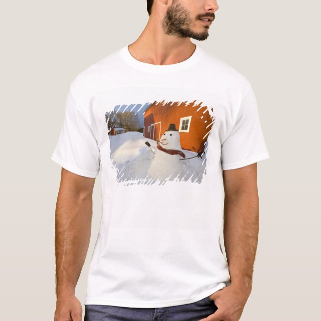 Snöman framför röd lada i Columbia Falls Tee (Framsida)