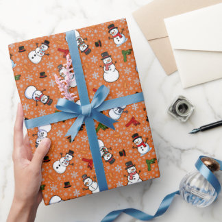 Snömän och snöflingor på mörkt orange presentpapper