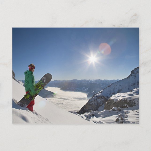 Snowboarder tittar från bergstoppen vykort (Framsida)