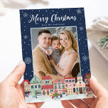 Snowy Winter Village God jul 2 Photo Julkort<br><div class="desc">Skicka semesterhälsningar till familj och vänner med ett jokerkort från Snowy Winter Village från Late Bloom Paperie! Festive helgdag card visningar "God jul" överst i ett fet vitt skript. Grund på kortet har en snöstad vinterstad som dekoreras av jul ljus, helgdag, Julgranar och snögubbe! Snöflingor gräns kortet i vit och...</div>