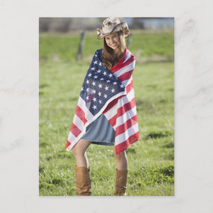 Snygg cowgirl inslagen i amerikansk flagga vykort