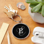 Snyggt Black Calligraphy-skript Monogram Namn Rund Silverfärgad Nyckelring<br><div class="desc">En vacker nyckelring med en elegant snyggt som återger ditt namn och monogram med klassiska seriffer och en mer ornerad manustypografi i en balanserad och symmetrisk harmoni. De tre inslag blandas ihop med en sofistikerad harmoni och skapar din egen logotyp för personlig märkning. Här visas chicens svarta bakgrund med monogram...</div>
