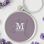 Snyggt Calligraphy Monogram och Namn Lila Rund Silverfärgad Nyckelring<br><div class="desc">En vacker feminin-nyckelkedja med elegant snyggt namn och monogram med klassiska seriffer och en mer ornerad manuskalligrafi i en balanserad och vacker layout. De tre inslag blandas ihop med en sofistikerad harmoni och skapar din egen logotyp för personlig märkning. Här visas trendig med dammig lila bakgrund med monogram inslag i...</div>