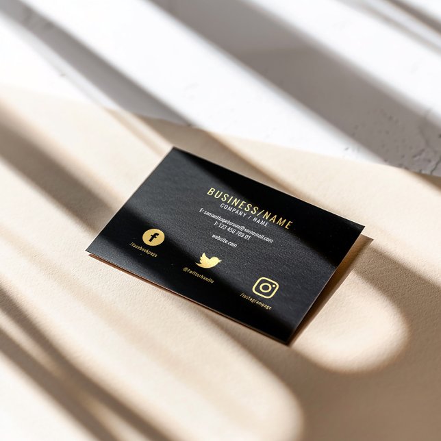 Social media Bold black and lyxury guld Visitkort (Black business card with gold text and social media icons on matte background.)
