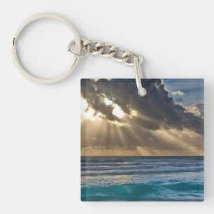 Sol bryter genom moln över havet
