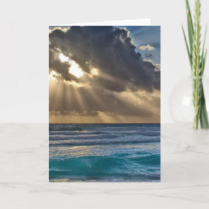 Sol bryter genom moln över havet kort