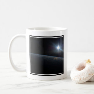 Sol sätter sig över jordens Horisont. Kaffemugg