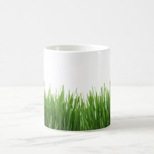 Soligt ljust - grönt gräs fotograferar trycket kaffemugg