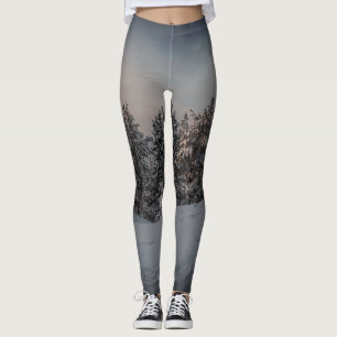 Solnedgång över fryst snöskog nära havet leggings