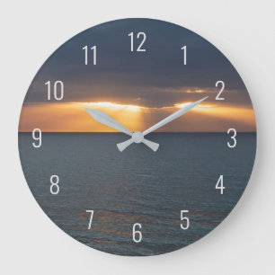 Solnedgång över havet genom molnen stor klocka