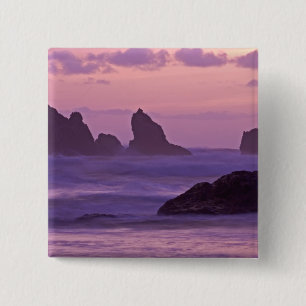 Solnedgång vid Bandon Beach Sea Stacks. Knapp