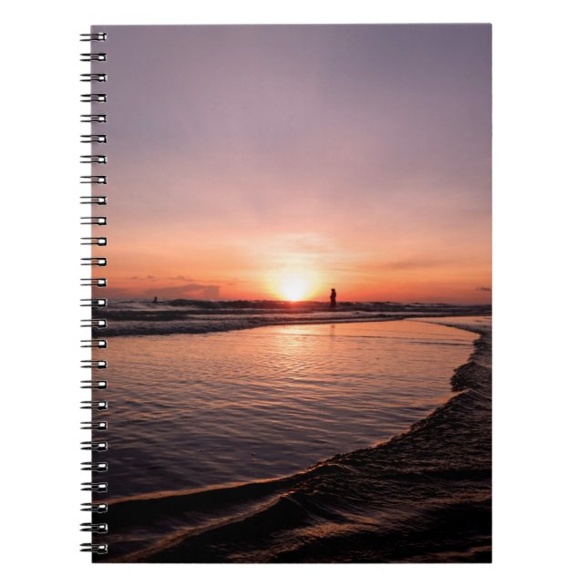 Solnedgången på stranden är mörk ljus och stark so anteckningsbok (Framsidan)