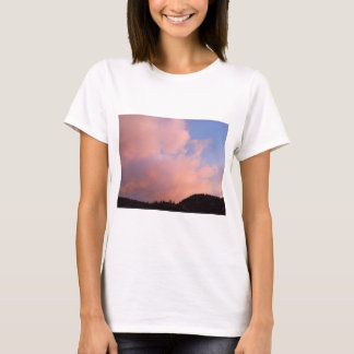 Solnedgångshimmel med rosa moln över silhuetterade t shirt