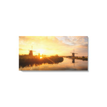 Soluppgång över vindkraftverk och en flod i Nederl