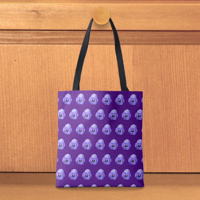 Sömlös väskmodell med lila penséer tygkasse (Tote bag with seamless pattern of a purple pansy)