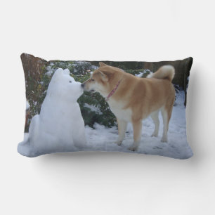 Söt akita hund kyssar snögubbe vid jul lumbarkudde