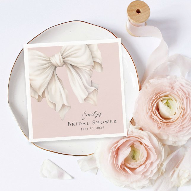 Söt, flickaktig, elfenbensvit rosett på rosa bröll pappersservett (Skapare uppladdad)