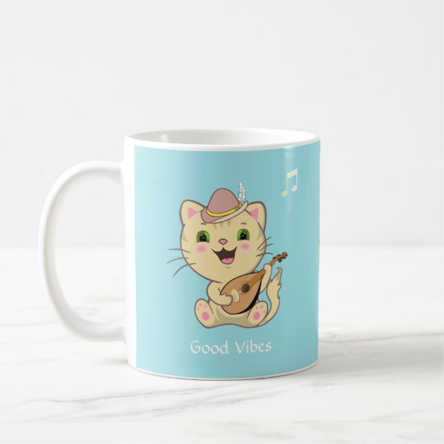 Söt glad musikalisk gulbrun tabbykatt på ljust blå kaffemugg (Vänster)